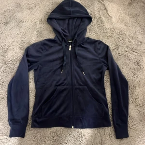 Mörkblå zip up från Gina Tricot XS - Mörkblå zip up från Gina Tricot i storlek XS. Tröjan har dragkedja framtill, huva med snörning och två fickor. Mjuk och skön, perfekt för chill dagar. Klassisk passform och långa ärmar.