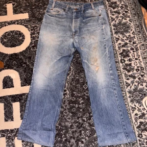 Levi's orange tab jeans - Ljusblå Levi's jeans med klassisk orange tab på bakfickan. Modellen har rak passform och fem fickor, med slitningar och blekta detaljer på framsidan. Jeansen är tillverkade i robust denim och har knappgylf. Perfekt för dig som gillar vintage vibe. 
