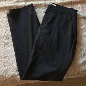 Svarta kostymbyxor från Woodbird - Sjukt snygga svarta kostymbyxor från Woodbird i klassisk rak modell. Köpta på Kennedies nyligen och använda fåtal gånger, därav i princip nyskick. Storleken är 30🔥 