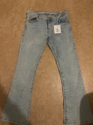 Ljusblå low flare jeans L/31 - Säljer ett par ljusblå jeans från bikbok i modellen Low Flare. De har låg midja och utsvängda ben. Helt nya aldrig använda 