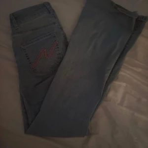 Ljusblå jeans från Nelly med broderad ficka - Snygga ljusblå jeans från Nelly med klassisk femficksdesign och en cool rosa broderad detalj på bakfickan. Perfekt för dig som gillar stilrena och trendiga jeans.