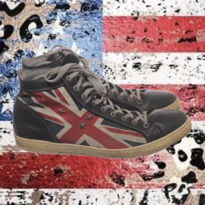 Vintage unika sneakers brittisk flagga🇬🇧 - Snygga svarta sneakers med brittisk flagga på sidorna och stjärndetaljer. Skorna har snörning, beige sula och är tillverkade i skinn med textilfoder. Perfekt för dig som vill sticka ut med en cool brittisk touch.