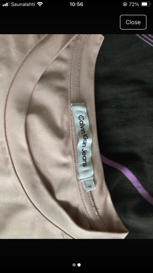 Beige t-shirt från Calvin Klein Jeans - Säljer en stilren beige t-shirt från Calvin Klein Jeans i storlek S. Toppen har rund halsringning, korta ärmar och ett diskret tryck med loggan på bröstet. Materialet är mjukt och har en lätt glansig finish som ger en fräsch look.