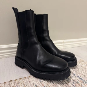 Svarta boots från Tiger of Sweden - Säljer ett par supersnygga svarta skinnboots från Tiger of Sweden med chunky gummisula och hög skaft, då de tyvärr är för små för mig.   Endast använda någon enstaka gång, så de är som nya!   Nypris 3000 kr.  Pris kan diskuteras vid snabb affär.