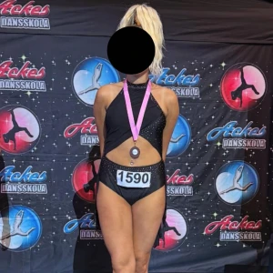 Svart slowdräkt med strassdetaljer - Säljer min slowdräkt med glittrande strassdetaljer och öppen rygg. Klänningen har asymmetrisk kjol i tunt tyg, halterneck och flera smala band i ryggen. Snygg cut-out framtill och hög slits på sidan. Perfekt för dig som vill sticka ut på dansgolvet!