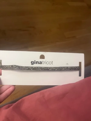Glittrigt halsband från Gina Tricot - Snyggt halsband från Gina Tricot med glittriga stenar i silverton. Halsbandet är smalt och har justerbar kedja för perfekt passform. Perfekt accessoar för att lyfta din outfit med extra bling.