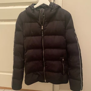 Jacka Lagency - Säljer denna svarta puffer jacka från Lagency. Den är i riktigt bra skick, varm inför vintern och är sparsamt använd. Storlek Large/Medium (den är en liten Large modell). Svart färg med silvriga dragkedje detaljer 🤩. Priset kan sänkas vid snabb affär! Hör av er vid frågor 😊