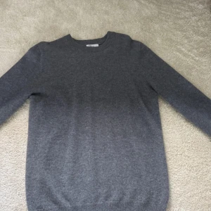 Grå stickad tröja i kashmir - Mjuk och stilren grå stickad tröja från Soft Goat i kashmir. Rund halsringning och ribbade muddar vid ärmslut och nederkant. Perfekt för dig som gillar enkel och clean look. Passar dig som vill ha en klassisk tröja med skön passform.