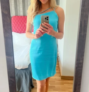 Turkos klänning - Snygg turkos klänning med one shoulder-design och smala axelband. Perfekt för event, bröllop eller fest.  