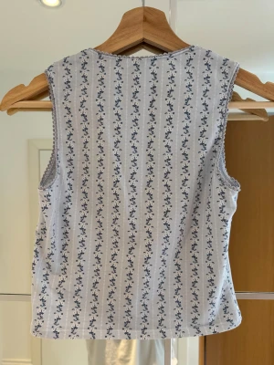 Topp med picotkanter - Kort linne / tanktop i mjuk bommulstrikå med fyrkantig urringning och söta spets kanter.  Mönstrad / randig / blommig.  Mörkblå / ljusblå / vit. Storlek XS/S. 