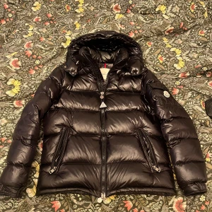 Moncler Maya  - Svart moncler Maya i storlek 2 vilket är S-M. Säljer den då den inte används längre. Väldigt fint skick och är använd fåtal gånger!                           (PRISET GÅR ATT DISKUTERA)