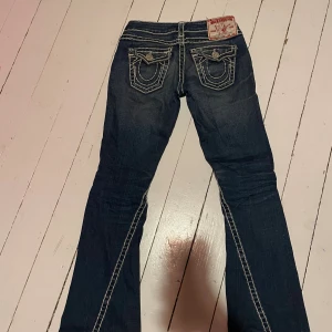 True Religion white stitch jeans W26 - Supersnygga white stitch True Religion jeans, bootcut i storlek W26. Köpta från vinted. Synligt slitage i änden av ena benet, vilket visas i sista bilden. Pris kan diskuteras 💕