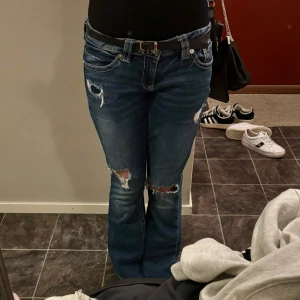 Gina Young Jeans - Säljer ett par blå jeans med bootcut passform och snygga slitningar från Gina Young. Jeansen har vita broderade bakfickor och är lågmidjade!☺️