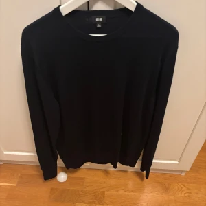 Marinblå stickad tröja från Uniqlo - Svart stickad tröja från Uniqlo i storlek L men funkar mer för M.Tillverkad i 100% ull, pris är förhandlingsbart och de bara att skriva vid frågor eller funderingar.