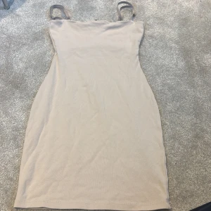 Kort Beige Klänning från Zara - En kort beige klänning från Zara i storlek S, säljer då ja inte tycker den sitter bra på mig. Klänning går lite högre upp än till knäna.