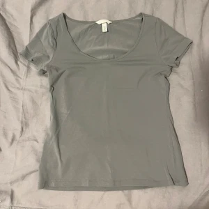 Ljusgrön t-shirt från H&M - Enkel och stilren svag- mintgrön t-shirt från H&M med rundad urringning och korta ärmar. Tillverkad i mjuk bomull som känns skön mot huden. Perfekt att matcha med jeans eller kjol för en clean look. Passar som storlek S-M och är även aldrig använd