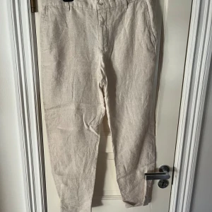Beiga linnebyxor med resår från Zara - Snygga beiga linnebyxor med avslappnad passform och resår i midjan baktill. Byxorna har raka ben, sidfickor fram och diskreta bakfickor. Perfekta för en chill och stilren look under varmare dagar.