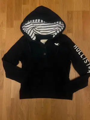 Snygg mörkblå hoodie från Hollister med vit broderad logga på bröstet,  stort Hollister-tryck längs ena ärmen och knappar 🔵| Storlek L men passar som S                                                              skriv vid funderingar                                             priset kan självklart diskuteras!!