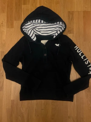 Vintage hollister kofta / cardigan  - Snygg mörkblå hoodie från Hollister med vit broderad logga på bröstet,  stort Hollister-tryck längs ena ärmen och knappar 🔵| Storlek L men passar som S                                                              skriv vid funderingar                                             priset kan självklart diskuteras!!