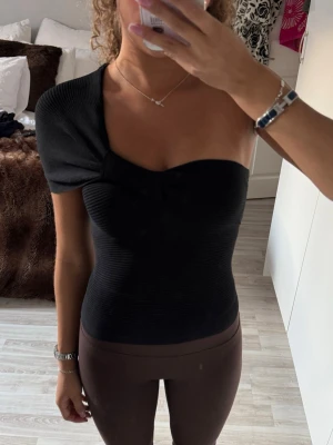 Svart oneshoulder ribbad Zara topp - svart ribbad topp med oneshoulder-design och kort ärm på ena sidan. Använd 1 gång, sitter som en xs