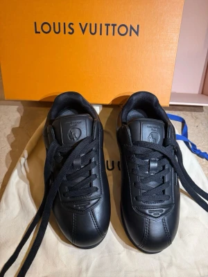 Svarta Louis Vuitton sneakers i skinn - Snygga helsvarta Louis Vuitton sneakers i skinn med klassisk LV-logga på sidan. Jag har aldrig använt dom fick dom som present priset kan diskuteras för mer info skriv!