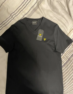 HELT NY Lyle & Scott T-shirt - Svart t-shirt från Lyle & Scott med v-ringad hals. Den är HELT ny 