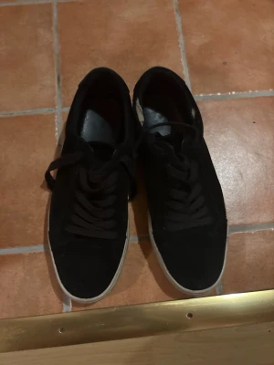 Svarta sneakers från Vagabond - Svarta sneakers från Vagabond med klassisk rund tå och platt vit sula. Skorna har snörning och är gjorda i mocka med insida i skinn. Stilrena och passar till många olika outfits. Snygg kontrast mellan svart ovandel och vit sula.