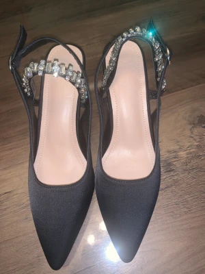Svarta pumps med strass och klack - Svarta pumps med glittrande strassdetaljer. Oanvända🤍