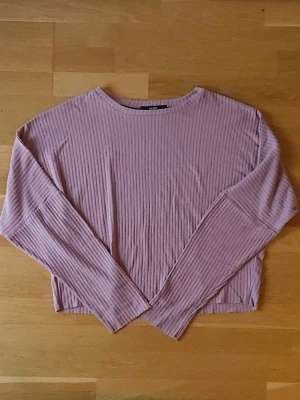 Rosa tröja - Mjuk och skön långärmad tröja från Bik Bok i en ljusrosa nyans. Tröjan har en avslappnad passform, rund halsringning och är tillverkad i ett stretchigt material som känns skönt mot huden. Perfekt att styla med jeans eller kjol.