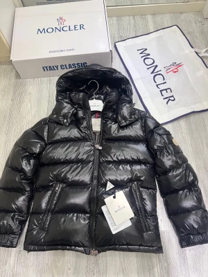 Moncler maya navy  - Hallå där! Nu säljer jag min Moncler Maya i stilrent svart. Denna jacka är i otroligt fint skick, sparsamt använd och utan några som helst defekter. Med sin fyllning av kvalitetsdun är den perfekt för att hålla värmen under både höst- och vinterdagar. Jackan är självklart äkta, inköpt direkt från Monclers officiella webbplats nyligen. Anledningen till att jag säljer den är att jag mestadels använder arbetskläder och inte hinner använda den så mycket som den förtjänar. Vid köp till ett bra pris i