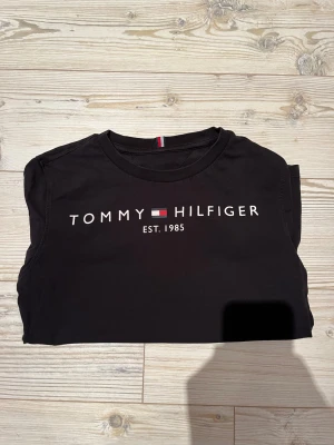 Svart Tommy Hilfiger t-shirt - Riktigt snygg svart-shirt från Tommy Hilfiger med text över bröstet.