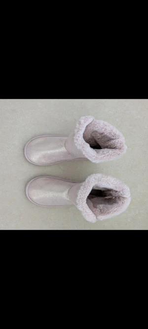 Ljusrosa fluffiga boots från H&M - HELT OANVÄNDA BOOTS. Säljer ett par ljusrosa boots från H&M i storlek 38/39. Skorna har en fluffig pälsimitation på insidan och utsidan, samt en glittrig finish på ovansidan. De har platt sula och rund tå, perfekta för kalla dagar. Supermysiga och trendiga för vintern!