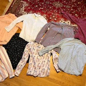 Mix av långärmade skjortor i olika mönster - Säljer ett gäng långärmade skjortor i olika färger och mönster – randigt, blommigt, rutigt och enfärgat. Skjortorna har knappar framtill och finns i material som bomull och linne. Perfekt för dig som vill variera din stil med allt från klassiska ränder till färgglada prints.