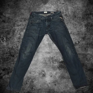 Replay Morex jeans mörkblå 30/32 - Snygga Replay Morex jeans i mörkblå tvätt med klassisk femficksdesign och subtila slitningar. Jeansen har raka ben och normal passform, med detaljerade sömmar och Replay-logga på bakfickan. Perfekt för dig som gillar stilrena och tidlösa jeans. Bara att höra av er vid intresse eller funderingar! 