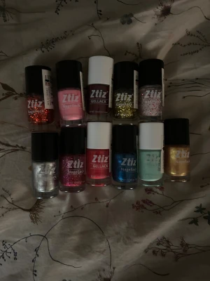 Nagellack i 11 olika färger - Säljer 11 helt oanvända nya olika nagellack från Ztiz, inklusive glitterlack i rött, guld, rosa och silver, samt vanliga lack i rosa, vinrött, blått, mintgrönt och guld.  Perfekt för dig som gillar att måla naglarna.