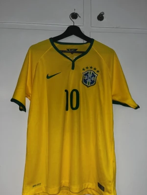 Ingen sko på bilden - Bilderna visar en gul Brasilien fotbollströja med Neymar Jr och nummer 10, inte skor. Ingen skobeskrivning kan ges.