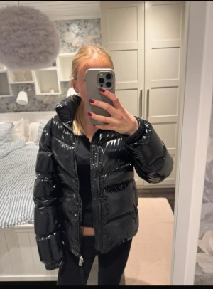 Svart glansig pufferjacka med dragkedja - Säljer en svart, glansig pufferjacka från colmar. Jackan är köpt på NK för 4499kr och har använts ca 3 gånger strl:172 men är som en xs. Skriv vid funderingar.🤍