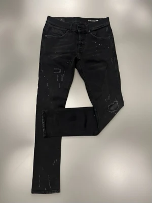 Dondup Jeans - Säljer ett par svarta skinny jeans med slitna detaljer och råa kanter. Skriv vid frågor eller funderingar!