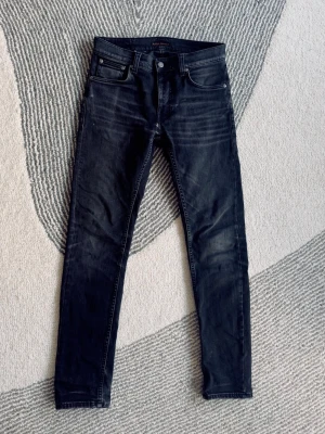 Nudie Jeans, Lean Dean 30/32 - Säljer ett par Nudie jeans, slim fit modell ”Lean Dean” W30 L32. Schyssta slitningar. En slitning vid gylfen, inget man tänker på.  (kan lämnas in på Nudie store- dom fixar slitningar gratis.) 
