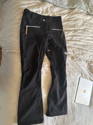 Svarta skidbyxor från CLWR, M - Säljer ett par svarta skidbyxor från CLWR i storlek medium. Perfekta för vinterns alla äventyr och riktigt sköna att ha på sig ❄️🥂Dragkedjan vid ena benet är sönder.