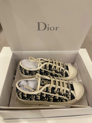 Dior Oblique sneakers i beige och marinblå - Säljer ett par Dior Oblique sneakers med marinblått och beige mönster. Måste bli av med dom så säljer dom billigt . Är inte andvända mer än 3 gånger 
