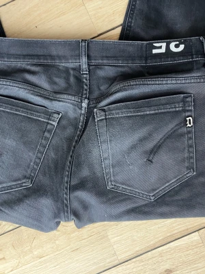 Svarta jeans från Dondup - Märke av ett litet hål vid skrevet precis som jag kan fixa bild på om du är Intereserad! Snygga svarta jeans från Dondup i modellen George. Jeansen har klassisk femficksdesign, raka ben och diskret logga på bakfickan. Tillverkade i ett mjukt och stretchigt denimtyg som sitter skönt hela dagen.
