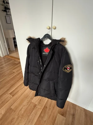 Svart dunjacka från ZAVETTI CANADA - Svart dunjacka med huva och fuskpäls från ZAVETTI CANADA. 