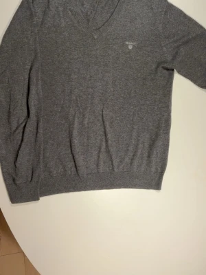 Gant stickad  - Mysig grå stickad tröja från GANT med V-ring. Säljer denna otrolig sköna tröja då den tyvärr blivit för liten. Hör av dig vid minsta fundering, pris ej hugget i sten vid snabb affär  
