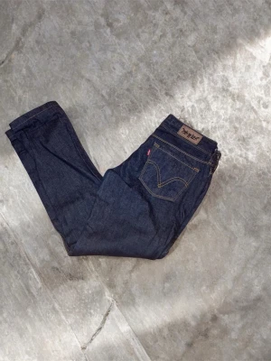Levi's 571 Slim Fit jeans mörkblå - Säljer ett par Levi's 571 Slim Fit jeans i mörkblå tvätt. Klassisk femficksmodell med snygga kontrastsömmar och Levi's ikoniska läderpatch bak. Jeansen har en smal passform och är tillverkade i slitstarkt.