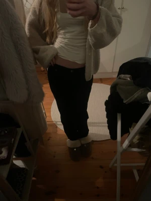 Svarta wide jeans från Olivia - Säljer ett par svarta jeans från Olivia med snyggt broderad detalj på bakfickan. Byxorna har wide passform och låg midja, perfekta för dig som gillar en avslappnad stil. Materialet är jeans och de har klassisk knapp- och dragkedjestängning.