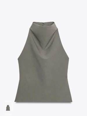 Grå halterneck topp Zara - Säljer en grå halterneck topp med krage och snygg drapering framtill. Toppen har knäppning i nacken! Helt ny endast testad! Köpt på Zara för ord pris 329kr