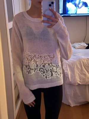 Vit stickad tröja med spetsdetalj - Superfin vit stickad tröja med bred spetsdetalj över magen. Tröjan har lång ärm, rund halsringning och ett blommigt spetsmönster som ger en söt och romantisk vibe. Säljer eftersom att det inte riktigt är min färg! Endast använd två gånger men köpt för ungefär ett år sen. (priset är diskuterbart) skriv om ni har några frågor.