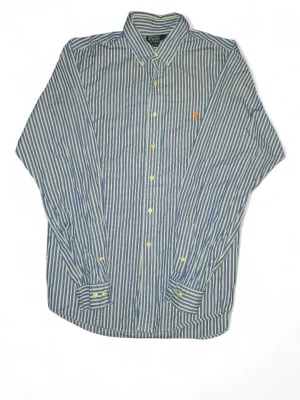 Randig blå skjorta från Polo Ralph Lauren - Snygg blå skjorta från Polo Ralph Lauren i storlek XL, custom fit. Skjortan har vertikala ränder i blått, vitt och gult, klassisk krage och knappar framtill. På bröstet finns den ikoniska orange broderade Polo-loggan. Perfekt för dig som gillar stilrena och tidlösa plagg.