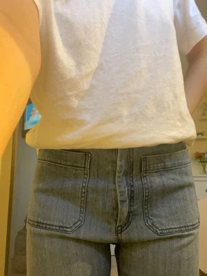 Blåa wide jeans med stora fickor - Säljer ett par blåa jeans med hög midja och breda ben. Jeansen har stora fyrkantiga fickor både fram och bak, och är gjorda i klassiskt jeansmaterial. Perfekt för dig som gillar en avslappnad och trendig stil. Från hm i strl 38, jeansen är ganska stretchiga.